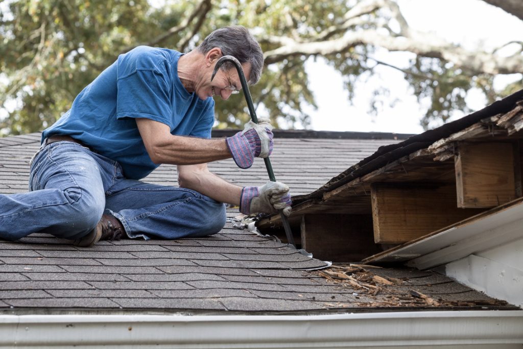 Man Fixing Damaged Shingle Roof